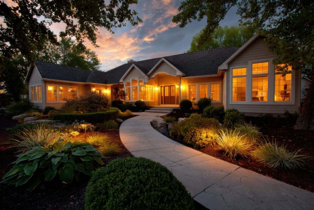 beautiful modern home with warm lighting and landscaped garden at sunset photo beautiful modern home with warm lighting and landscaped garden at sunset photo